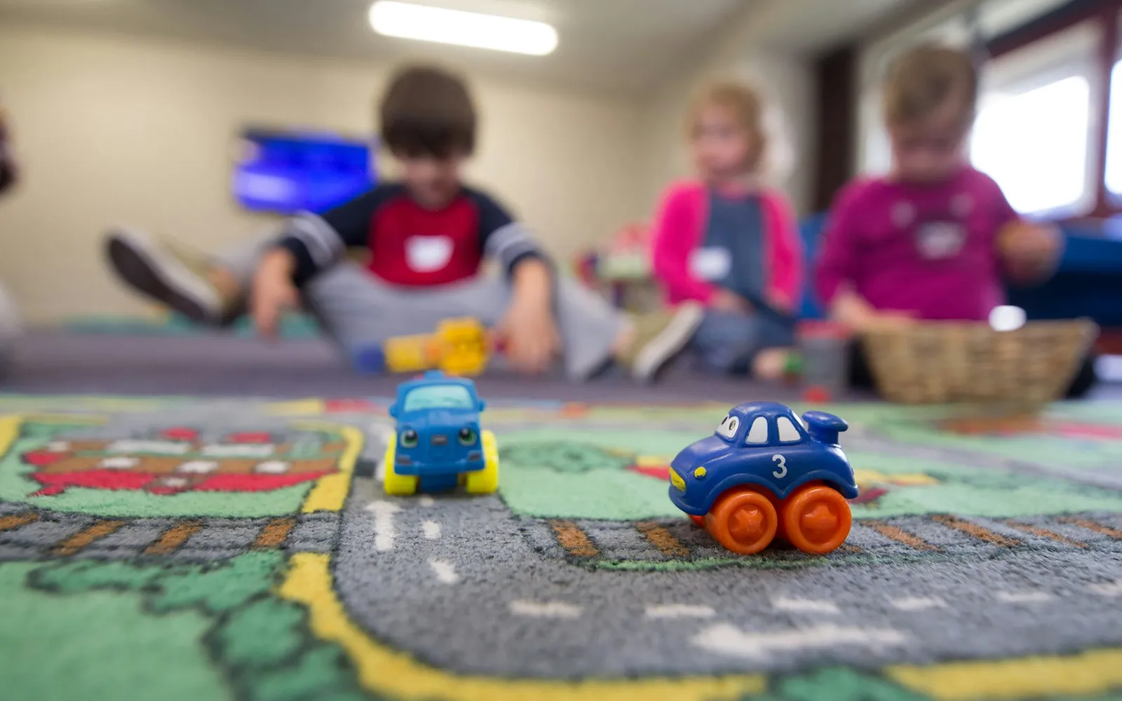 Toddlers playing with toys on a classroom floor