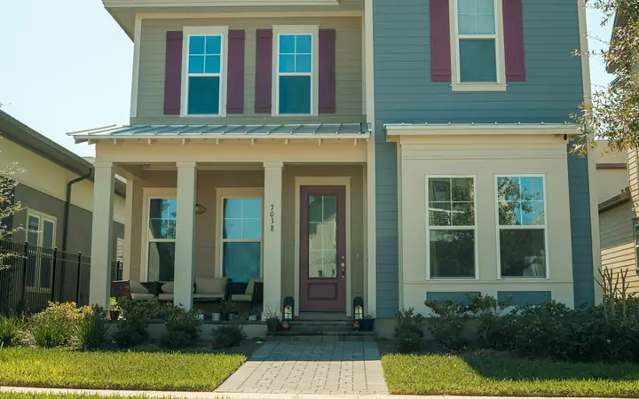 Two-story blue house with white trim and red shutters